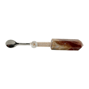 A spoon with a brown stone handle.