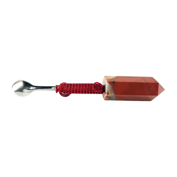 A spoon with a red string and a stone