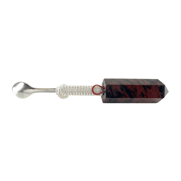 A red and black glass object with a metal handle.