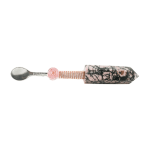 A spoon with a pink handle and a black and white pattern.