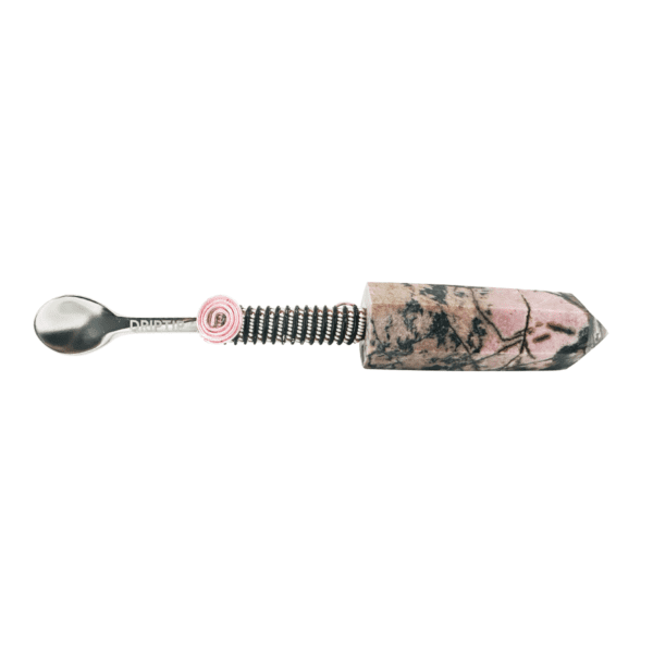 A spoon with a pink handle and a floral design.