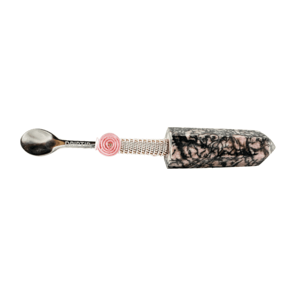 A spoon with a pink bead on it.