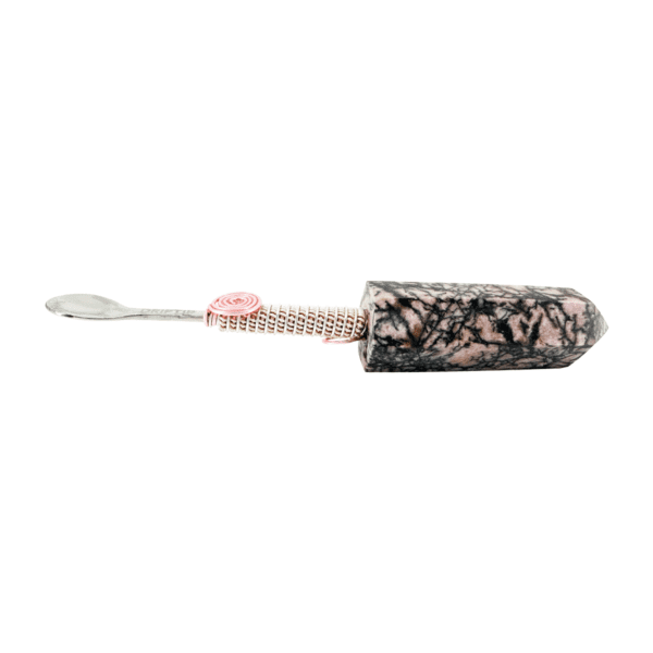 A black and white picture of a toothbrush with pink beads.