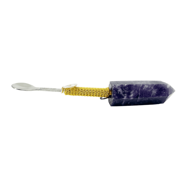 A purple stone with yellow handle and a metal spoon.