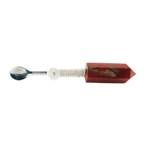 A spoon with a red handle and some brown things on it