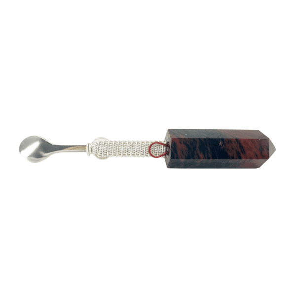 A brown and white spoon with a red handle.