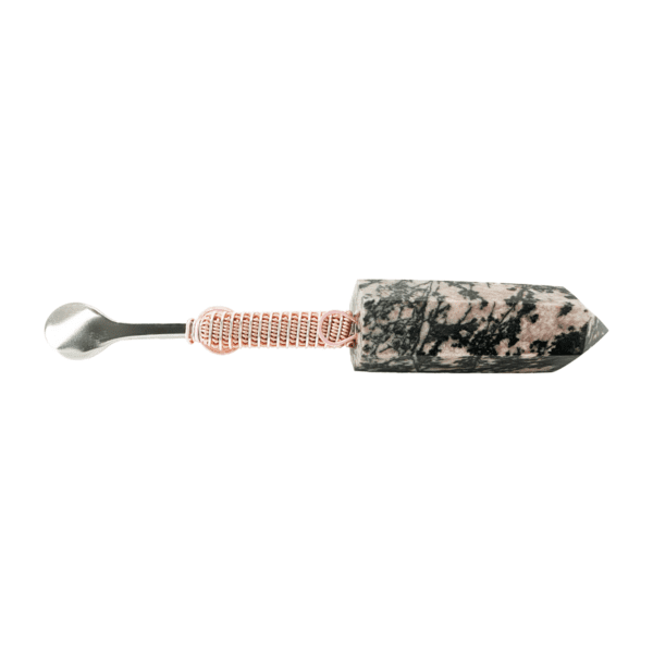 A spoon with a pink handle and black marble design.