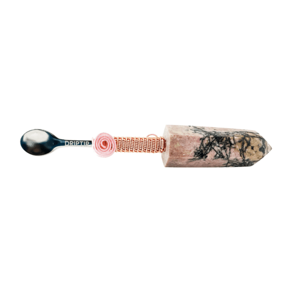 A spoon with a wooden handle and a pink bead.