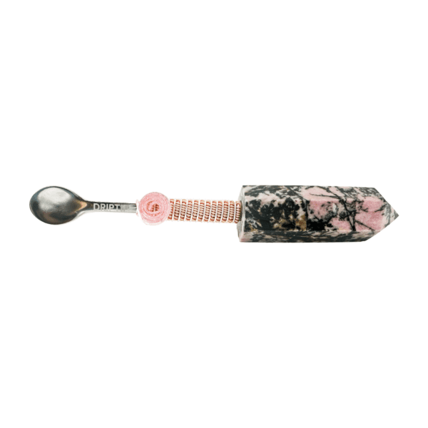 A spoon with a pink handle and black background