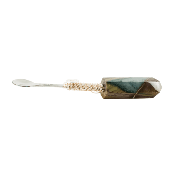 A toothbrush with a wooden handle and a green stone.