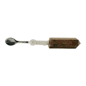 Silver spoon attached to a brown crystal.