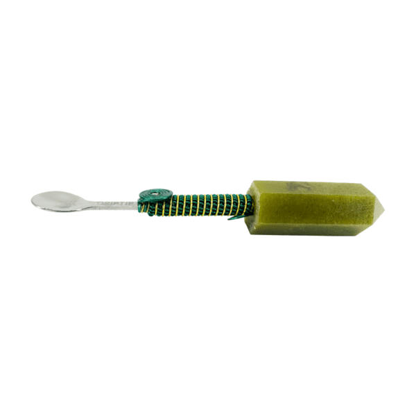 Green crystal attached to a silver spoon.